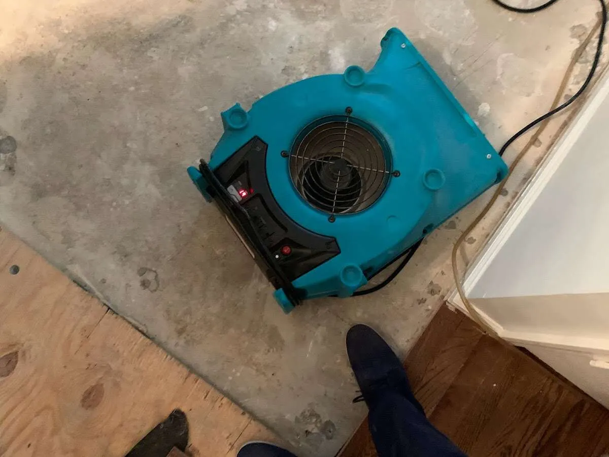 Air mover drying subfloor during Commercial Water Damage Restoration in Antigo